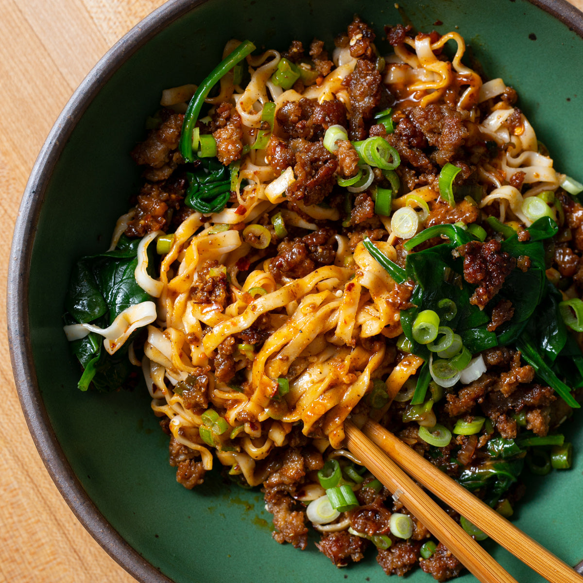 noodles with chili crunch pork and greens
