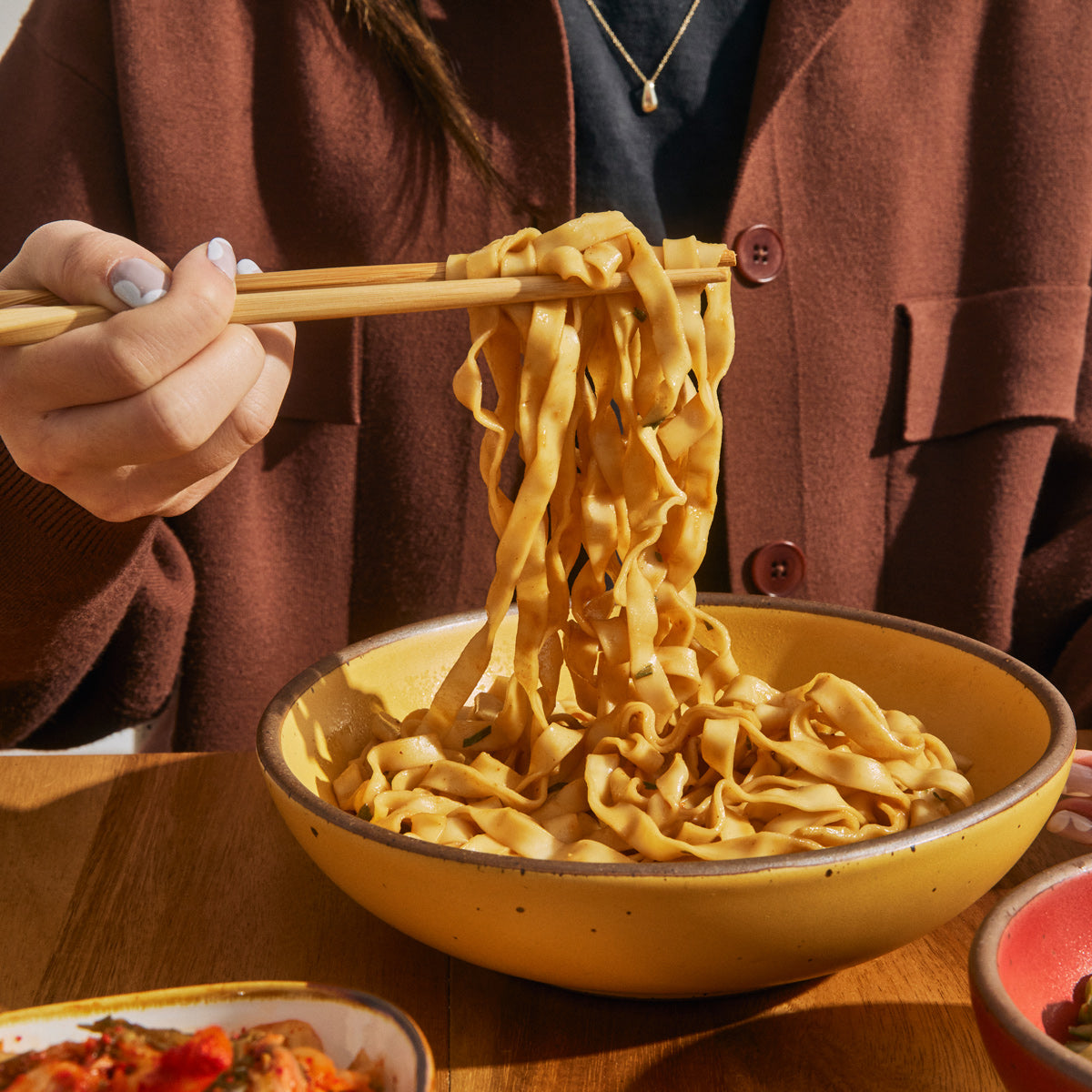 Wavy Noodles pulled by chopsticks in a bowl