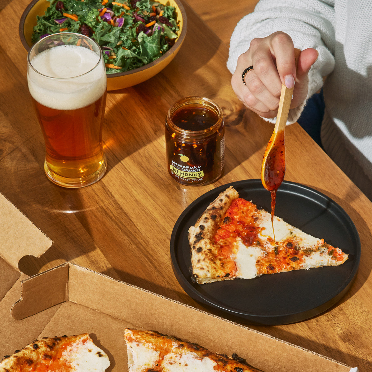 Chili Crunch Hot Honey being drizzled over pizza