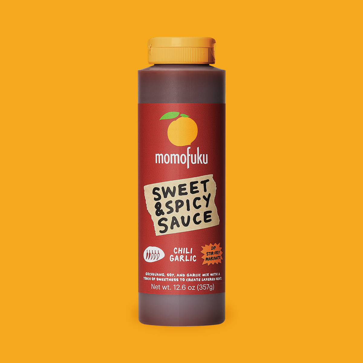 A bottle of Momofuku Sweet & Spicy Sauce (Chili Garlic flavor) centered against a solid orange-yellow background. The bottle is dark brown with a yellow cap and features a red label with a torn paper graphic.