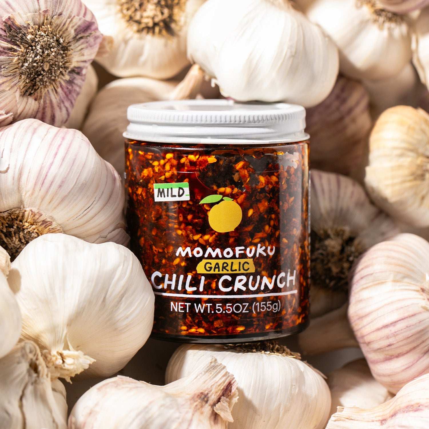 mild garlic chili crunch on bulbs of garlic