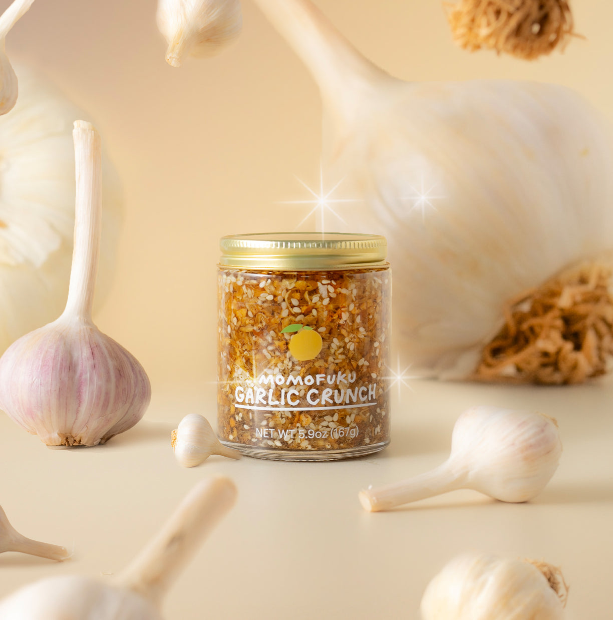 jar of Garilc Crunch with garlic bulbs in background