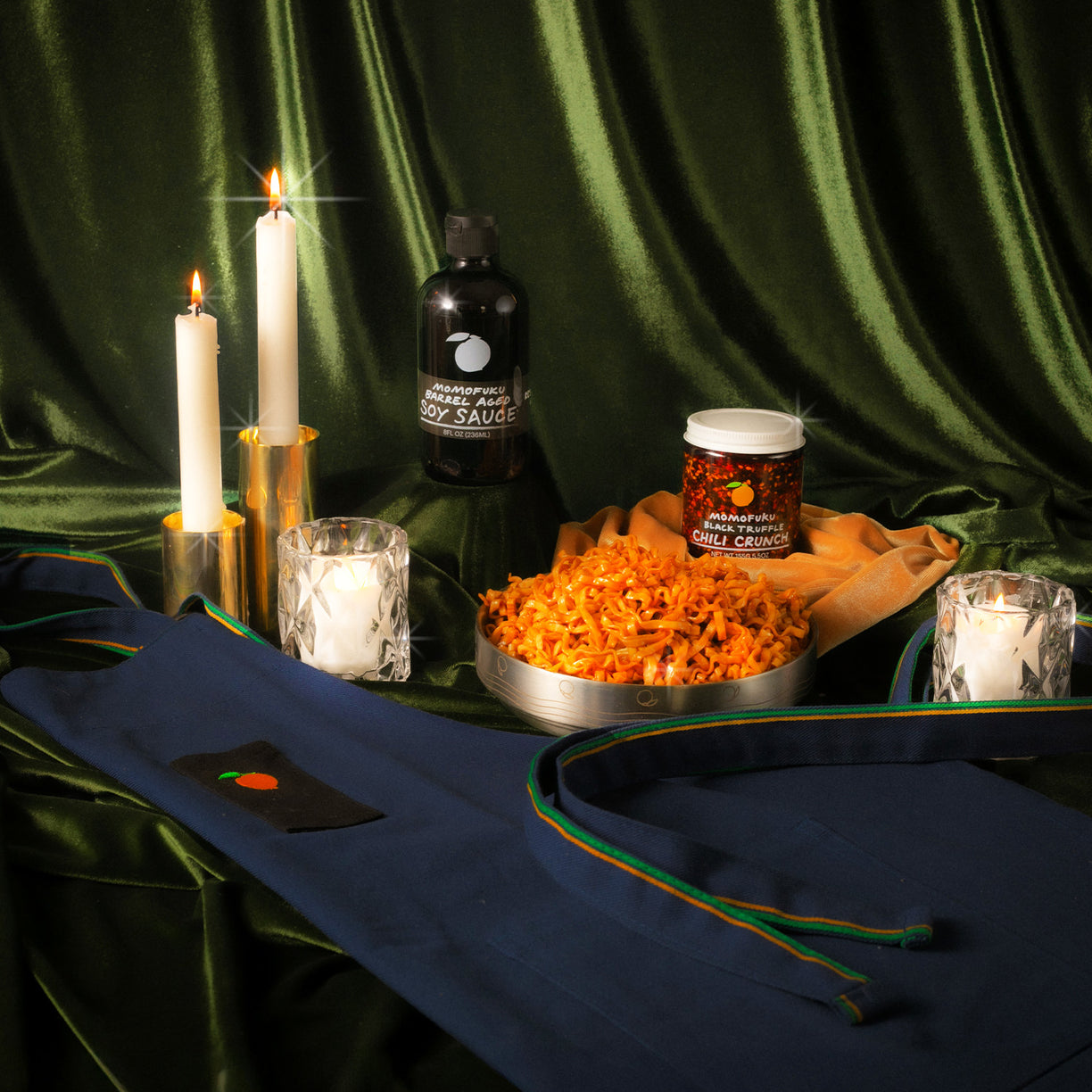 Barrel Aged Soy, Black Truffle Chili Crunch, Momofuku Noodle Bowl and Apron on festive background