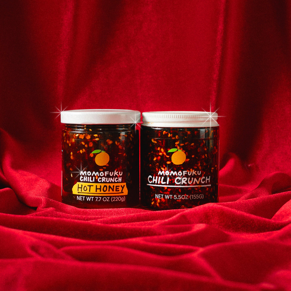 jars of chili crunch with red velvet background