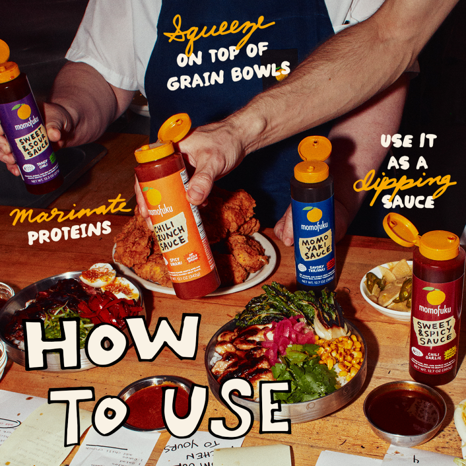 A lifestyle shot of a person wearing a blue Monopoly apron holding two bottles of Monopoly sauce, surrounded by food on a wooden table with text overlays explaining how to use the sauces.
