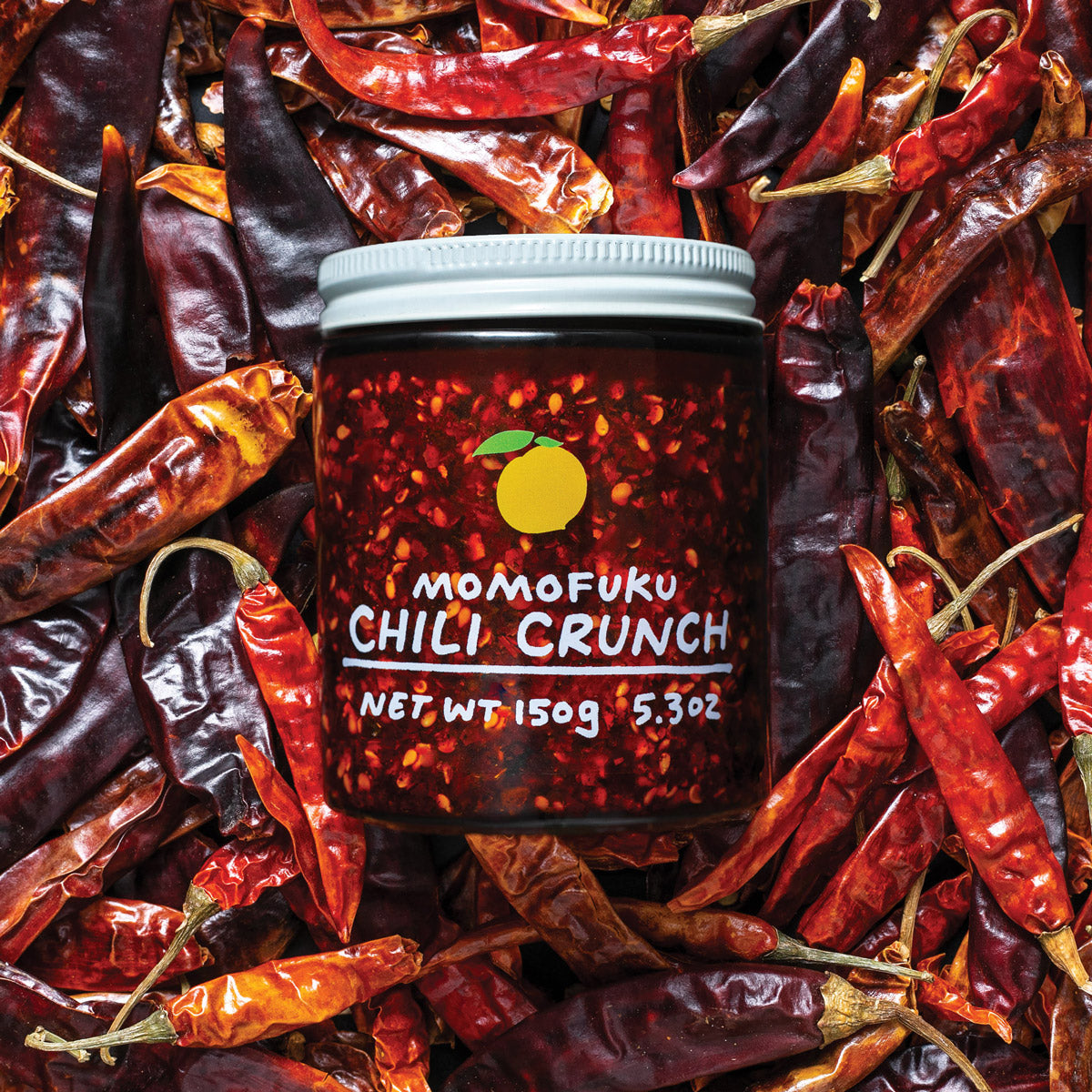 chili crunch jar on a bed of peppers