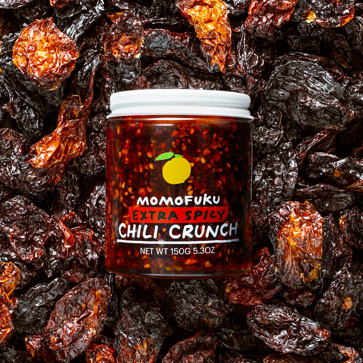 chili crunch jar on a bed of peppers